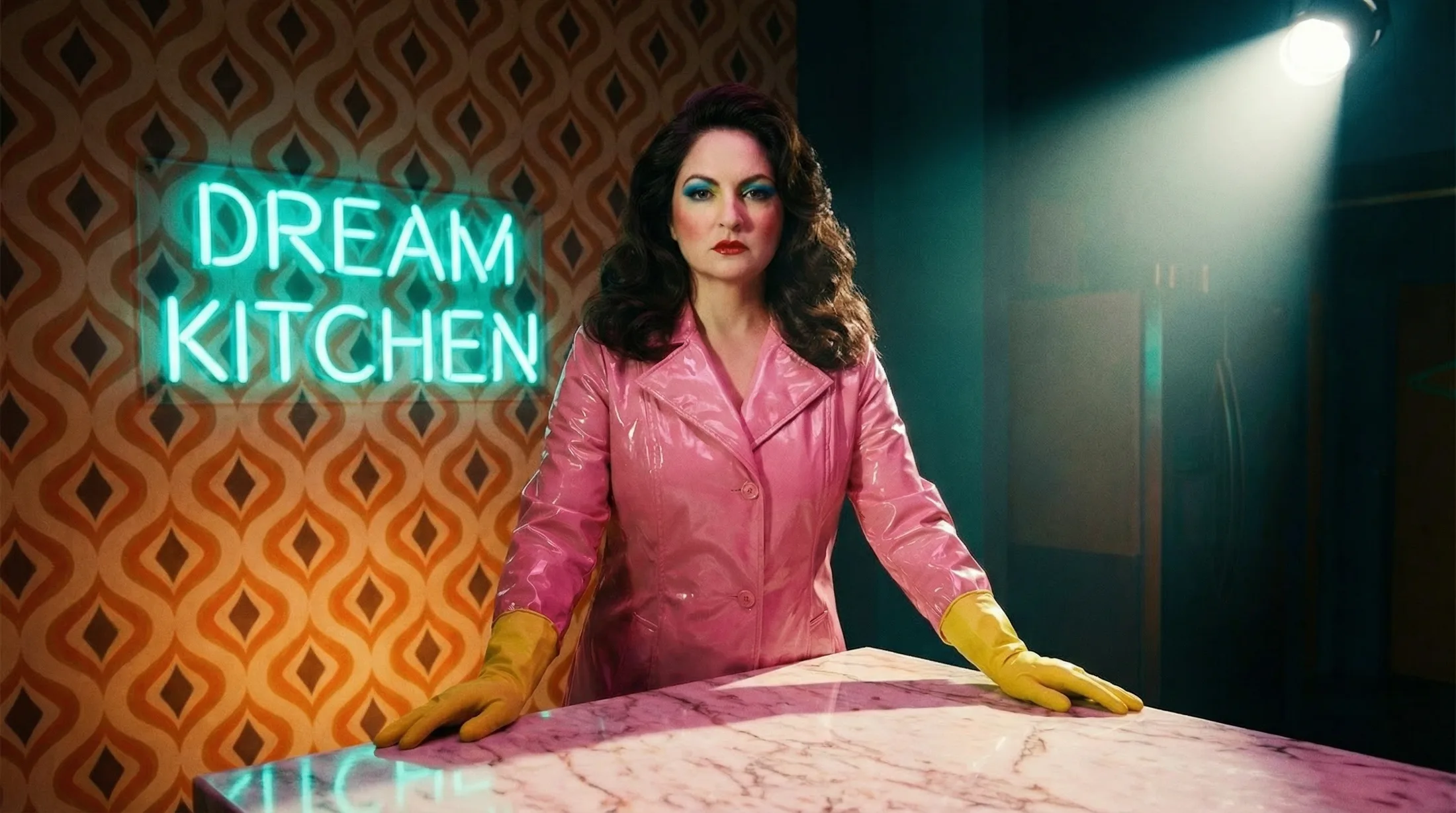 Anna behind the pink marble kitchen island under the Dream Kitchen neon